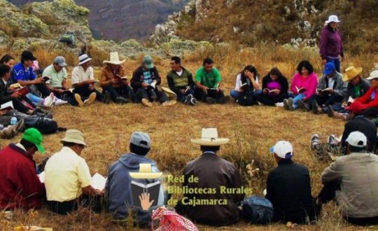 A circle of Peruvians reading together, outside