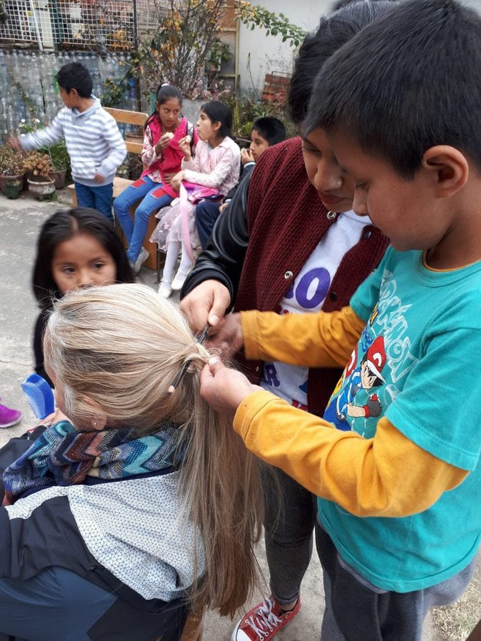 Young boy braiding solidarity participant's hair