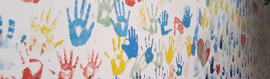 Multi-coloured handprints on a wall