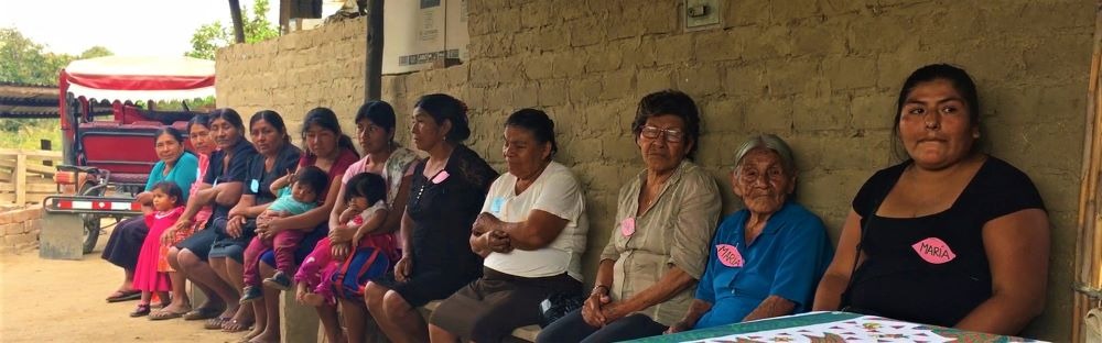 rural women sitting on benches in San Isidro
