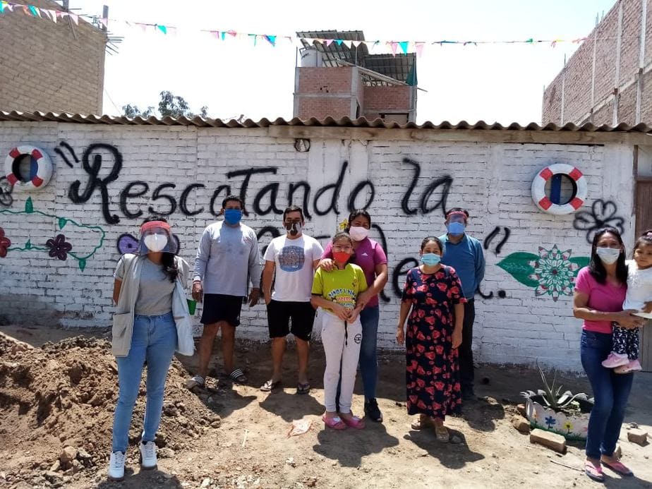people with spades and plants stand in front of walls that says rescuing our street