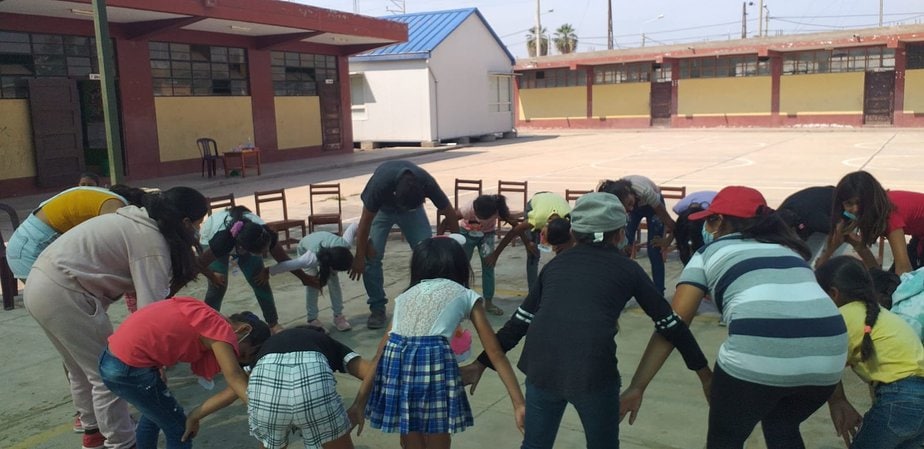 boys and girls in a circle bending over exercising