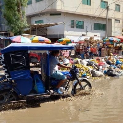 Mototaxi drives through flood waters and garbage in José Leonardo Ortiz