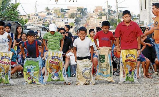 four boys compete in a sack race