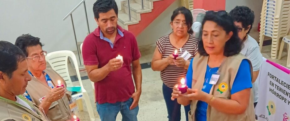 a group of six men and women hold candles