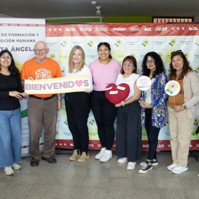 a row of men and women face the camera holding a sign that says bienvenidos