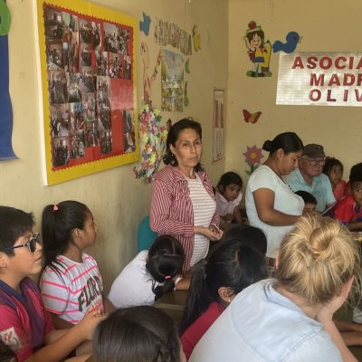 children sit at desks lined against one wall