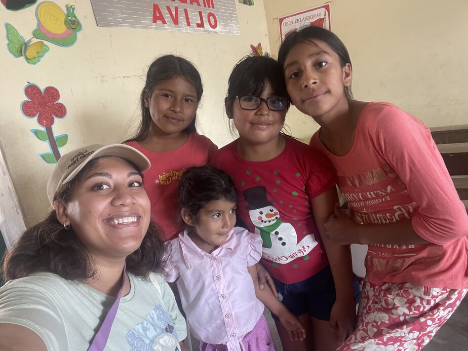 Heart-Links' ED Dani smiles for the camera beside several little girls in Nuevo Mocupe