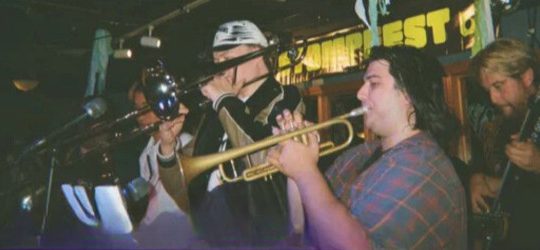 los freakies with trumpet, trombone and guitar players visible