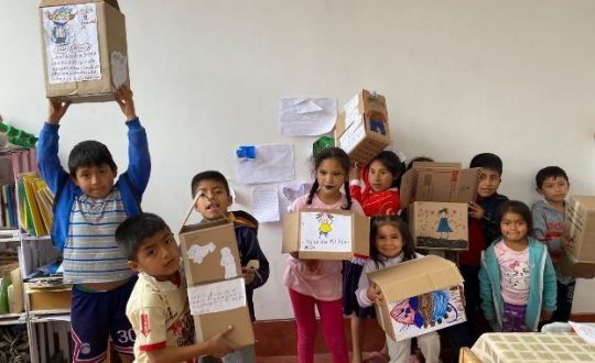 children hold up the crafts they have made