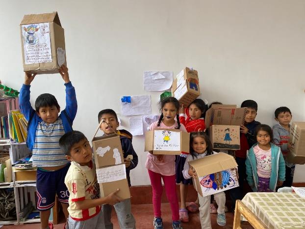 children hold up the crafts they have made