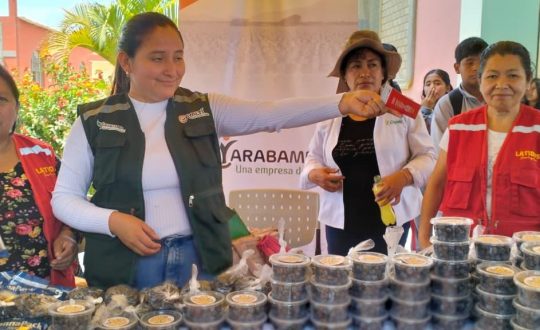 Women standing behind a table offer tips and samples of nutritious food