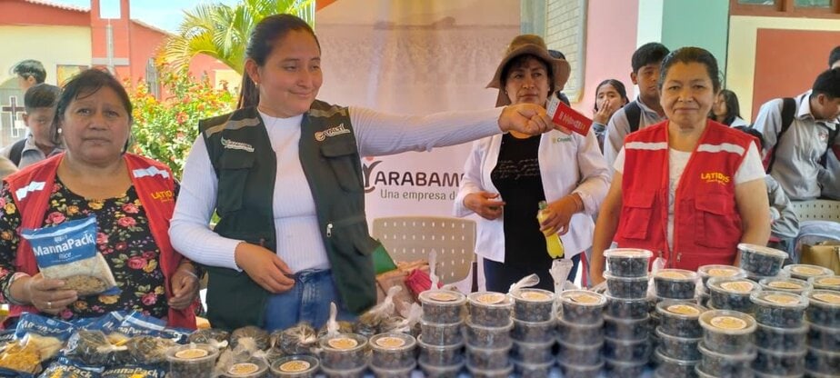 Women standing behind a table offer tips and samples of nutritious food